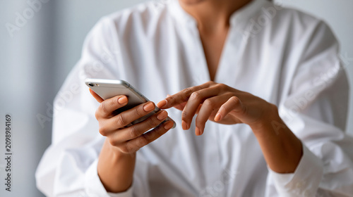 Close up of a womans hands using a smartphone against a bright clean background with soft even light hands only minimal composition business application smartphone mobile