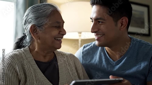 Grandmother and grandson using digital tablet together at home