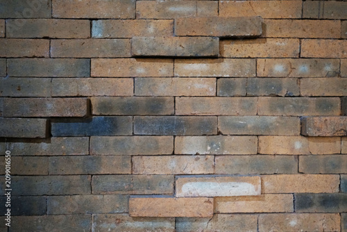 Bild auf Leinwand Rustic brick wall texture with weathered clay bricks in warm brown and charcoal tones