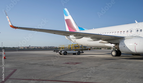 Cuadro en lienzo Passenger aircraft wing and tail parked on airport apron under clear blue sky sh