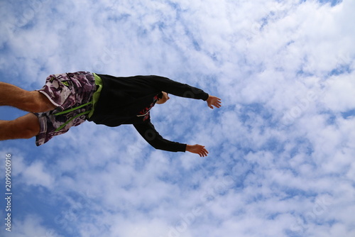 Male model deep backbend pose on beach, flexibility pose, acrobatic movement