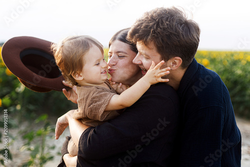 Canvastavla Happy family playing with son in sunny summer field