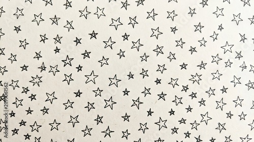 A white background with a pattern of small, black, star-like shapes scattered across it.