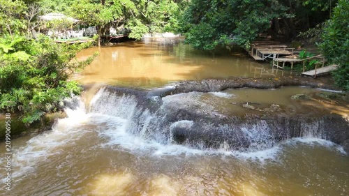 An aerial video showing a muddy waterfall cascading down from the mountains during Thailand's rainy season.