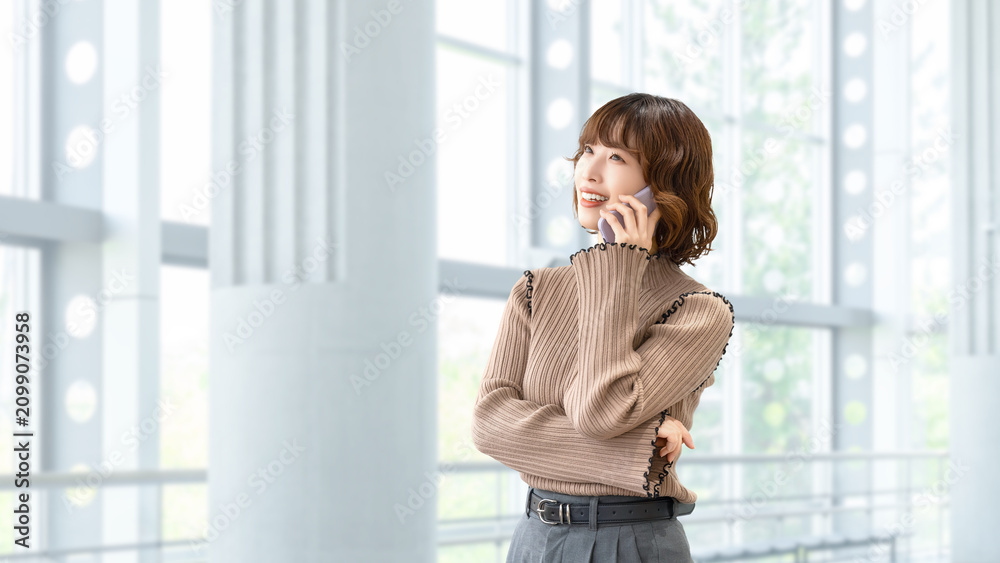 Fototapeta premium スマートフォンで話す笑顔の女性・ビジネスウーマン, Smiling Businesswoman Talking on a Smartphone