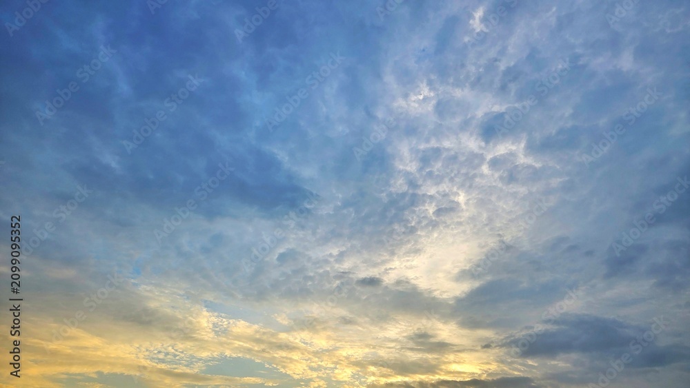 Obraz premium Beautiful Evening Sky Background, Golden Sunlight Piercing Through Stormy Blue Clouds landscape.
