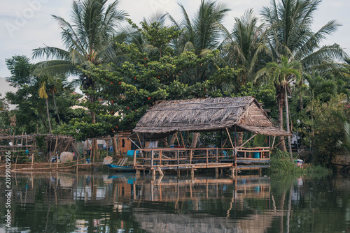 Rustic Thatched Roof Shelter Over a Peaceful River
