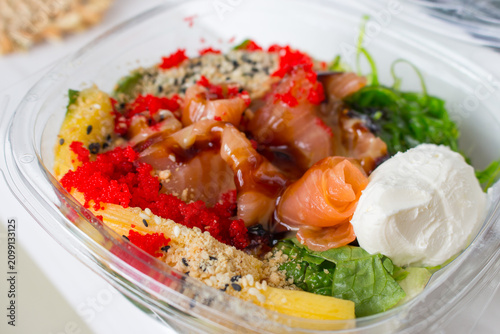Seafood bowl with rice and vegetables. Fresh food to go. Salmon with salad close up. Seafood restaurant menu. 