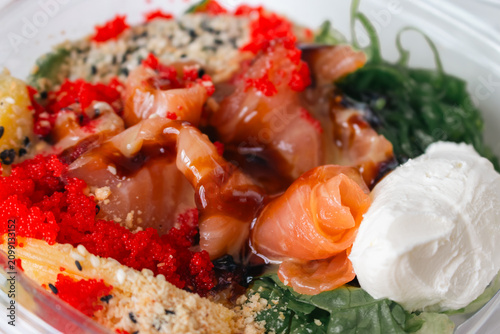 Seafood bowl with rice and vegetables. Fresh food to go. Salmon with salad close up. Seafood restaurant menu. 