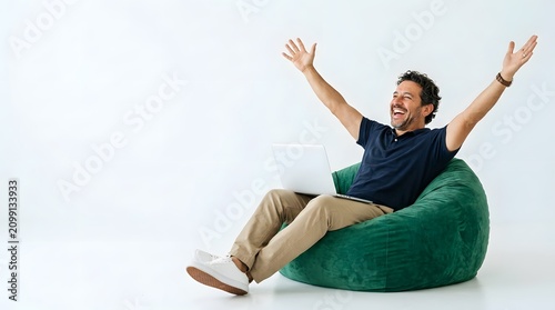 Happy man sitting on a green beanbag cheering