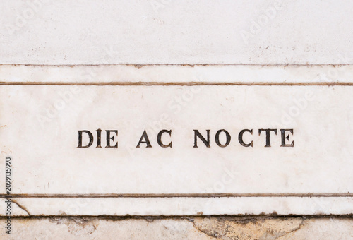 Foto Latin sentence meaning  day and nightcarved on marble plaque on the wall of a