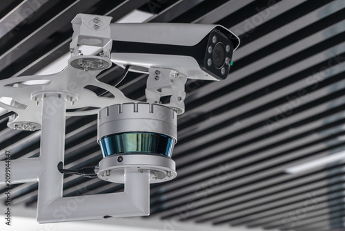 Ceiling-mounted surveillance setup featuring a security camera, CCTV unit and lidar sensor in a modern interior. Ideal concept image for monitoring, safety, technology and security