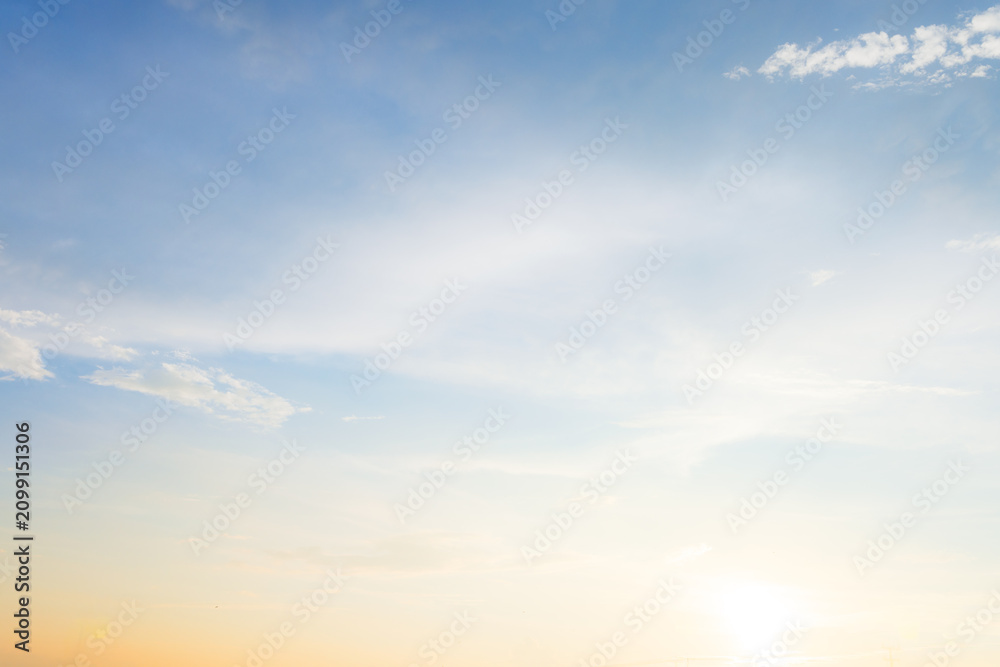 Fototapeta premium Dramatic golden hour sky with soft clouds at sunset,A beautiful and serene view of a golden hour sky, featuring soft, wispy clouds illuminated by the warm, gentle light of the setting sun, creating.