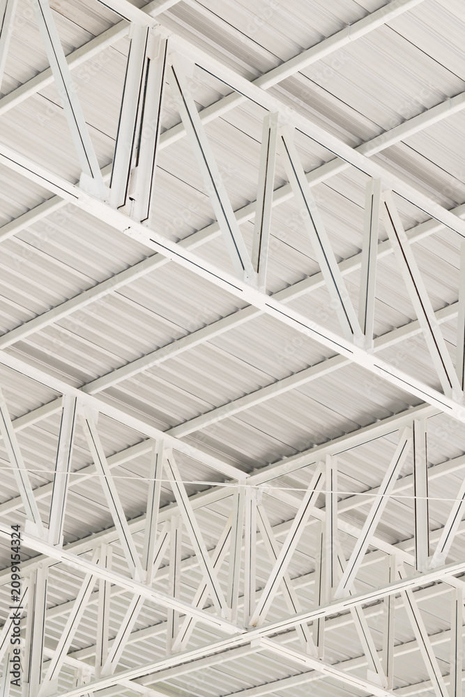 Fototapeta premium White Metal Roof Structure and Steel Truss Framework,Close-up view of a modern white metal roof structure featuring geometric steel truss patterns, architectural support beams, and industrial ceiling 