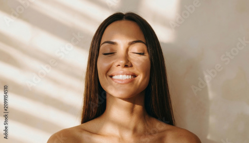 Fotografía Bathed in warm natural light, a woman with long brunette hair radiates pure cont