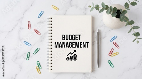 Budget management notebook on white marble background, financial planning spiral notepad with colorful paper clips, business accounting and savings concept