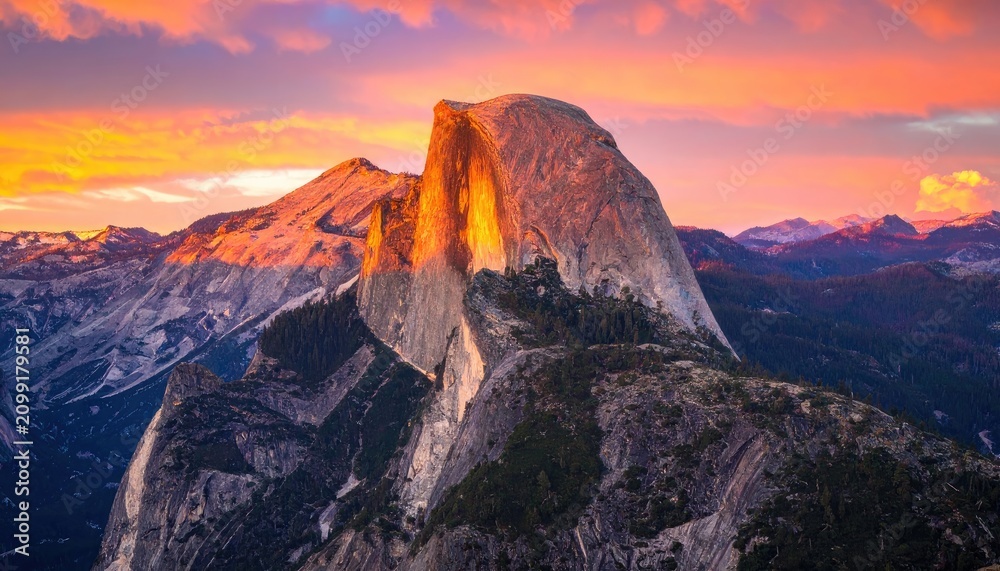 Naklejka premium Half Dome in Yosemite National Park illuminated by a vibrant sunset.