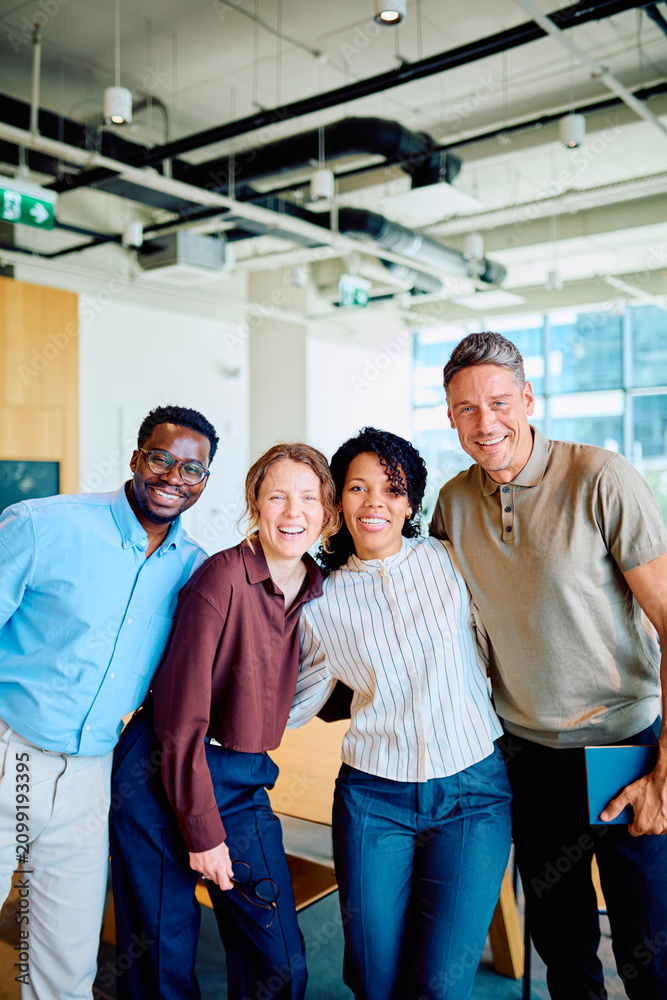 Naklejka premium Diverse business colleagues smiling and embracing in a contemporary office setting, representing teamwork, unity, and success