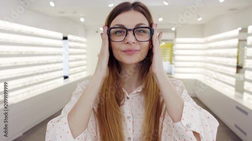Woman showcasing fashionable glasses in a store