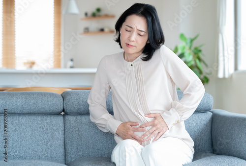 腹痛や胃痛に悩む女性　ミドル　主婦