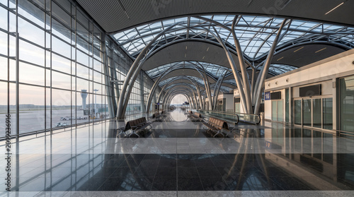 Futuristic Airport Terminal Interior Architecture with Glass Roof and Morning Sunlight