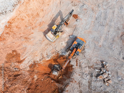 Fotografi Large tracked excavator with hydraulic hammer breaks asphalt at a construction s