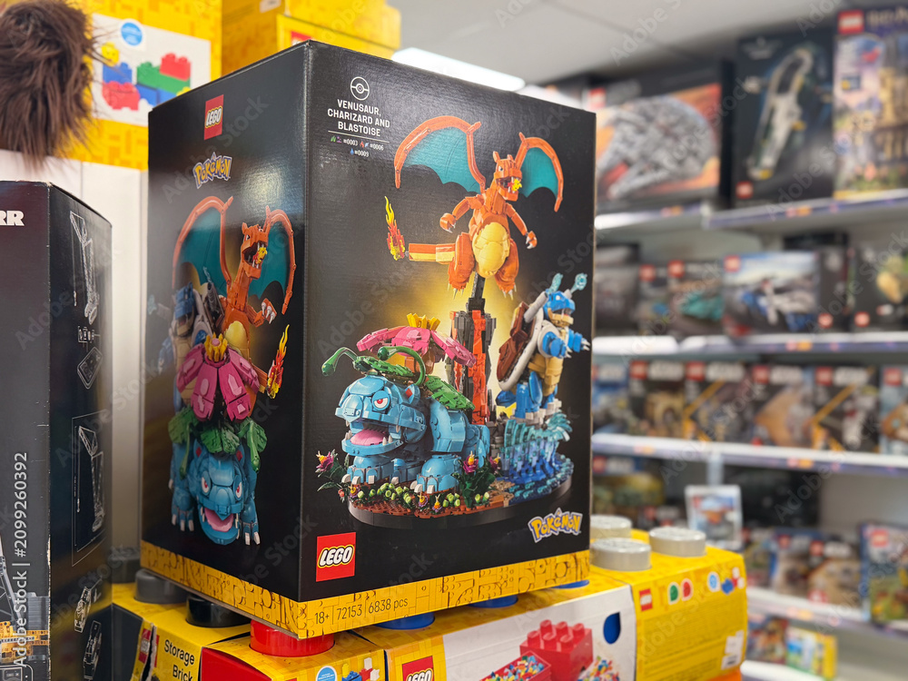 Fototapeta premium Lego pokemon building set boxes on a store shelf in a toy aisle, with colorful collectible box art and a blurred retail background.