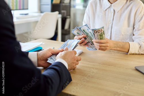 Fotografie Employee receiving cash salary from manager in office