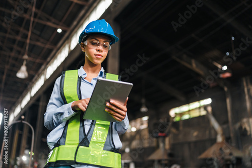 Картината върху платно Engineer factory tablet hard hat safety vest woman industrial worker inspection