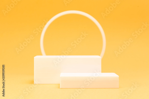 Minimalist white rectangular podiums with circle frame on warm yellow background