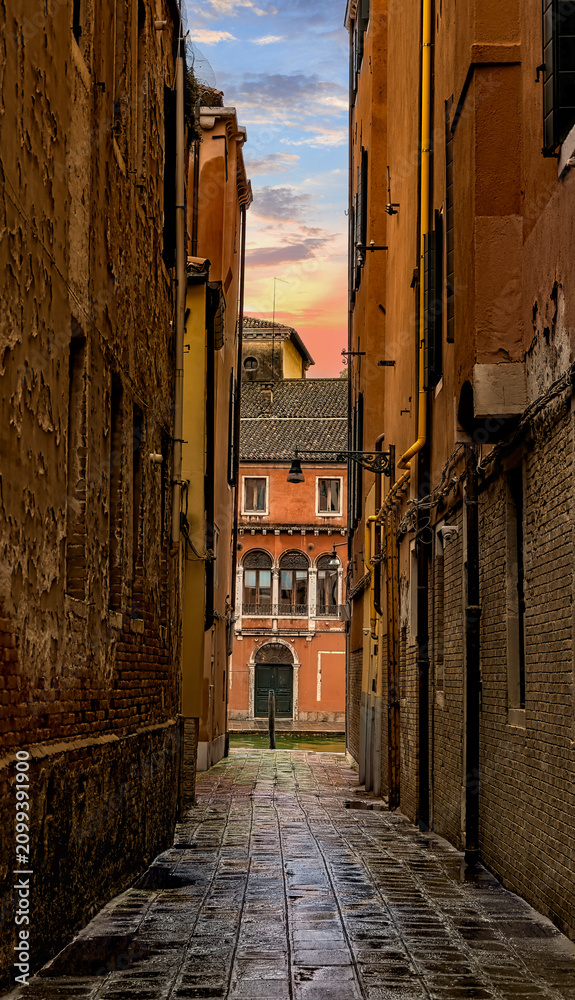 Obraz premium Old narrow streets or calles of Venice, Italy. at sunset