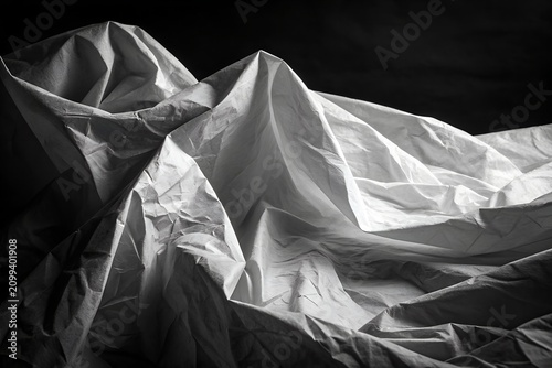 Dramatic black and white fabric draping with intense light and shadow
