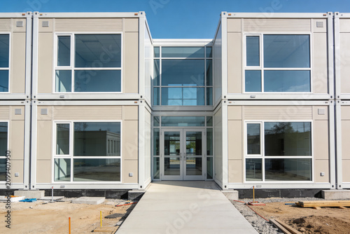 Modern modular building construction with stacked container units and large glass windows
