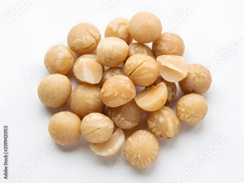 Pile of raw organic macadamia nuts isolated on a white background