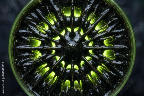 Ferromagnetic fluid spikes with glowing green backlight close up