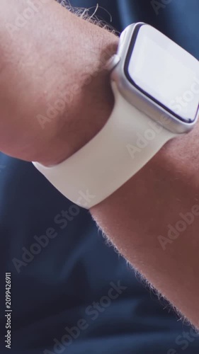 Vertical video: Rotating left wrist adjusting square watch after glare at home showing white band