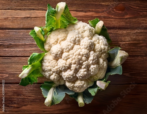 raw whole cauliflower on wooden background top view