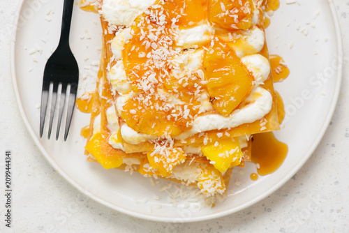 Картината върху платно Mille-feuille with caramelized pineapple, mango, whipped cream and coconut