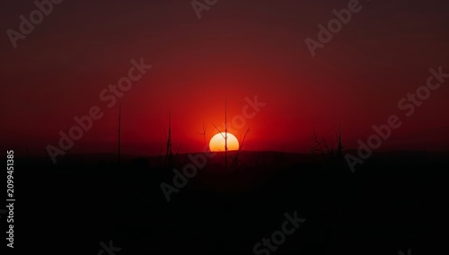 Sun Sets Over the Horizon During Evening Hours With Orange and Pink Hues