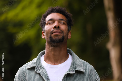 Peace and harmony. Happy man relaxing in park