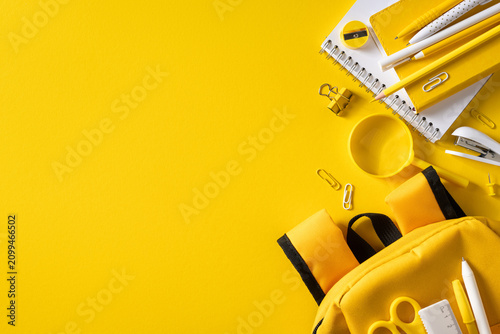 Fotografie Yellow back to school supplies flat lay with backpack, notebook and stationery o