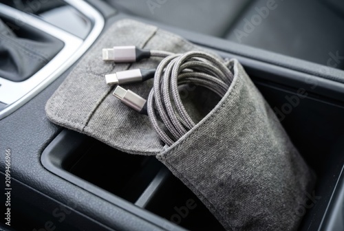 USB charging cables organized in a fabric pouch resting in a car console