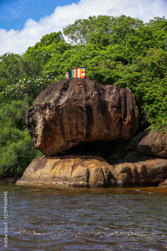 Large Rock Formation with Colorful Shrine in River