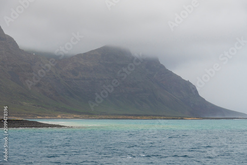 Lanzarote island in green in an unususaly rainy winter  province of Las Palmas Canary islands Spain Cliffs of northern Lanzarote from a boat sailing towards La Graciosa in the Chinijo Archipelago.