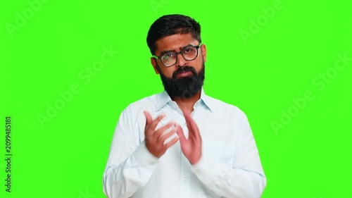 Indian man nods head with a friendly smile, expressing agreement and approval with confident positive energy. Arabian guy isolated on green chroma key background showing consent and supportive gesture