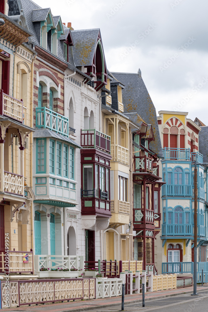 Fototapeta premium Houses of Mers-les-Bains, seaside town with 19th-century sea-bathing villas with colorful wooden balconies and white chalk cliffs, tourists destination in France