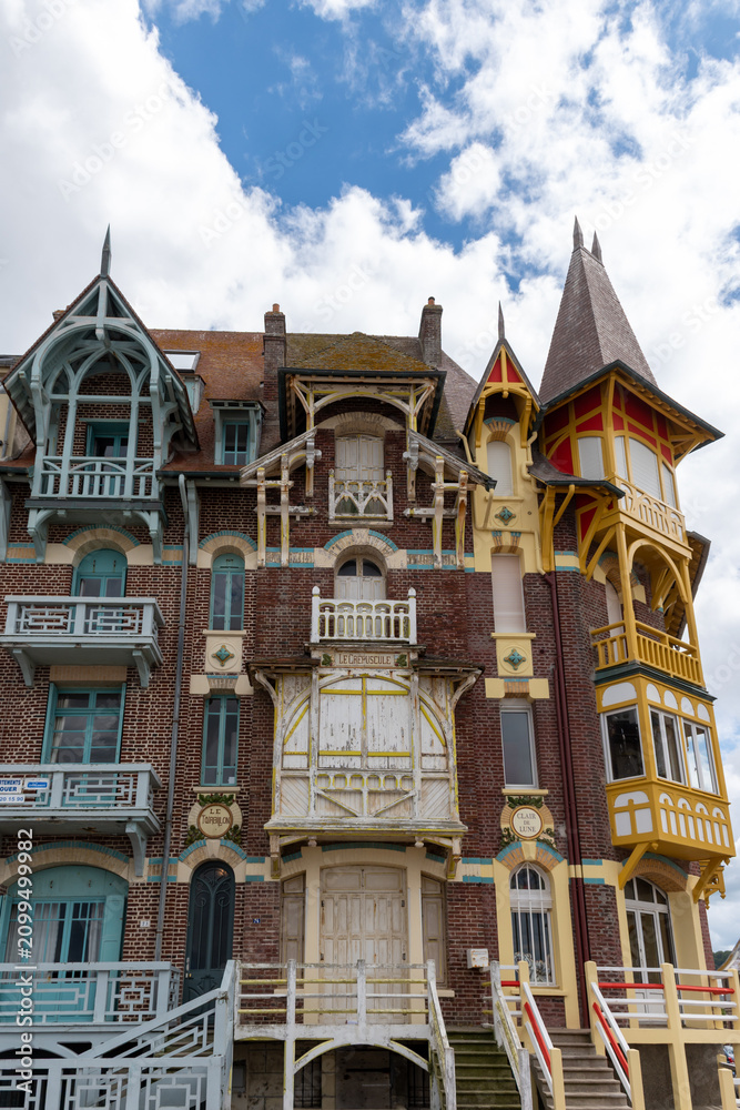 Fototapeta premium Houses of Mers-les-Bains, seaside town with 19th-century sea-bathing villas with colorful wooden balconies and white chalk cliffs, tourists destination in France