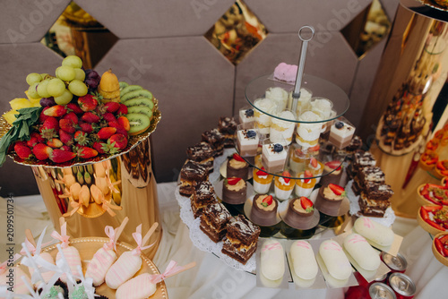 Foto Dessert buffet table offering sweet treats and fresh fruit
