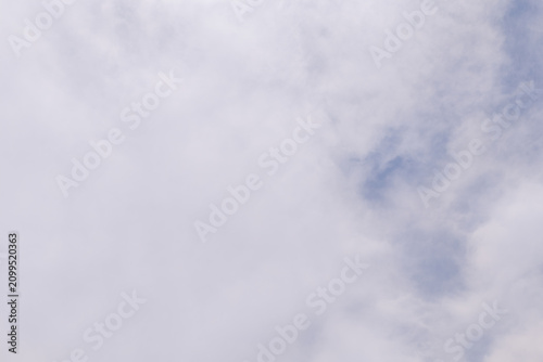Obraz na plátne Blue sky peeking through soft white clouds