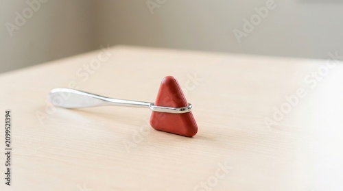 Reflex hammer on a light wooden table. Medical diagnostic tool for neurological examination